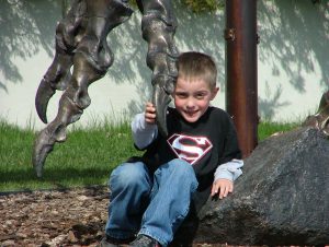 Bridger Lowery holding T-rex claw at Museum of the Rockies